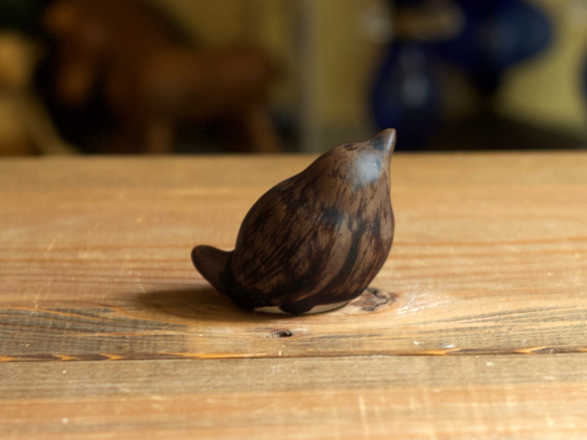 濃い茶色の鳥のオブジェを斜めから撮影。背中の先に短い尾が上がっています。