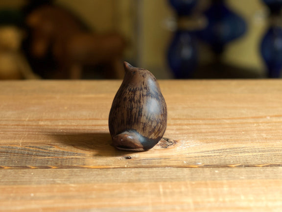 Höganäs Keramik の John Andersson がデザインした鳥のオブジェ。濃い茶色の釉薬で、頭を前に傾けた姿を正面寄りから撮影。