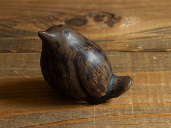 濃い茶色の鳥のオブジェの拡大。黒に近い筋が縦に流れる釉薬。